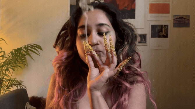 Anahita smoking with spikey gold nails on